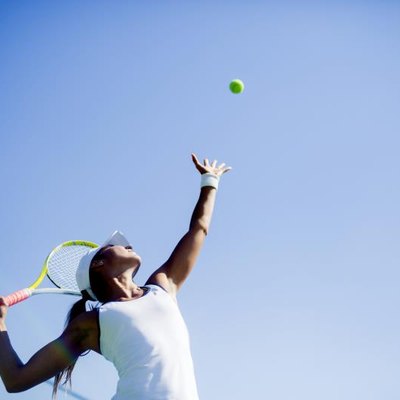 Beautiful female tennis player serving outdoor