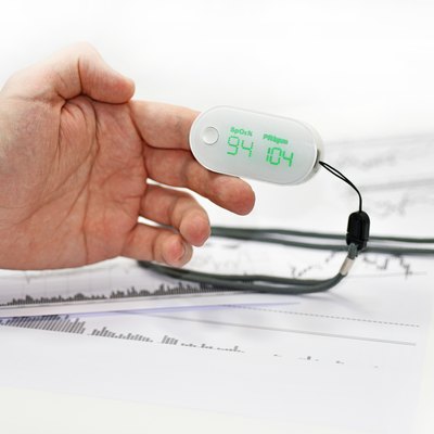 Blood oxygen meter on mans finger.