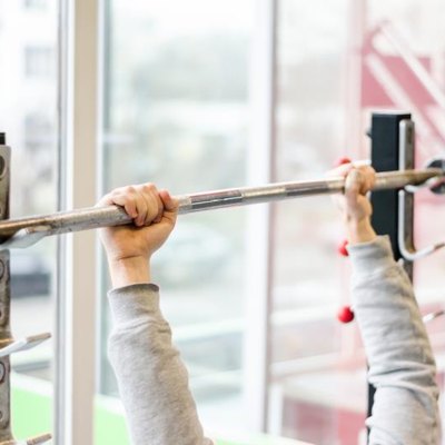 Arms of man working out in the gym, beginner athlete doing bench press exercise