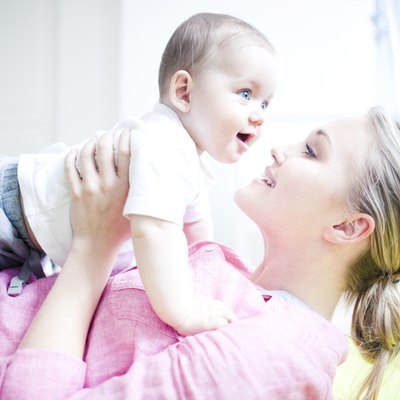 Teenage girl holding baby boy, close up