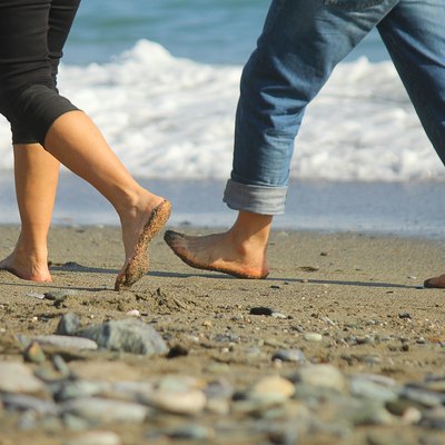 man and woman walking on the beach
