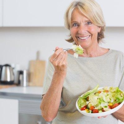 Smiling woman eating salad