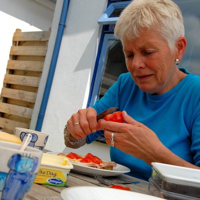 Elderly woman making lunch outdoors