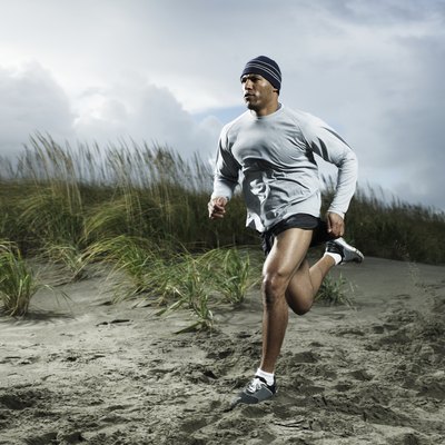 Muscular man running on beach