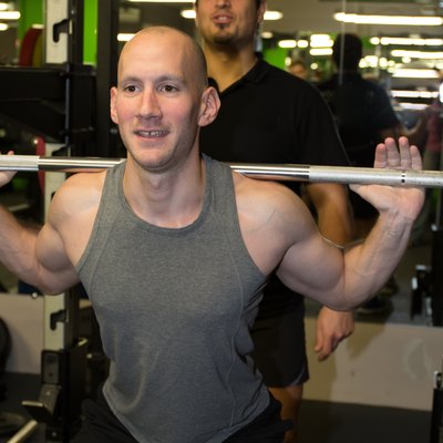 Gym personal trainer man with weight training equipment