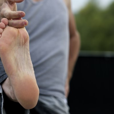 Man doing yoga hold his big toe.