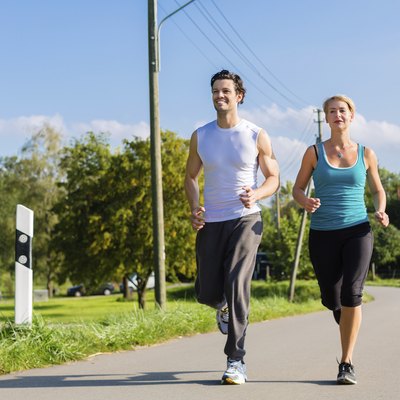 Sport couple running and jogging on rural street