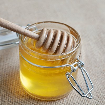Honey jar isolated on jute background