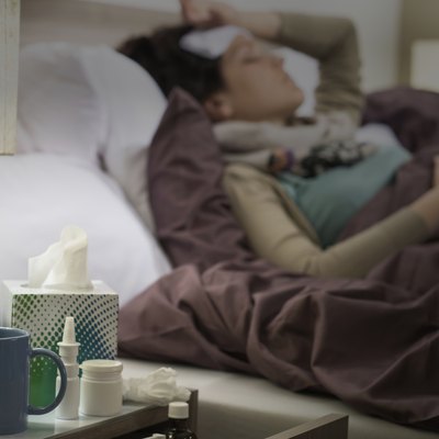 Tissue, flu medicines ill woman bedside table