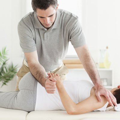 Masseur stretching woman's arm