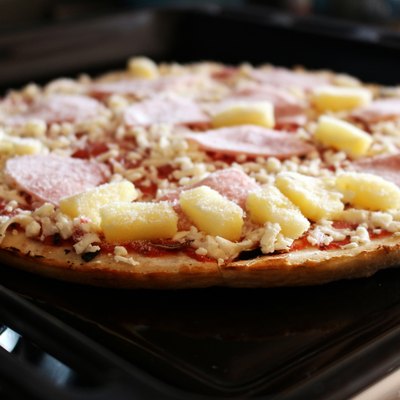 Frozen pizza with ham and pineapple on the plate