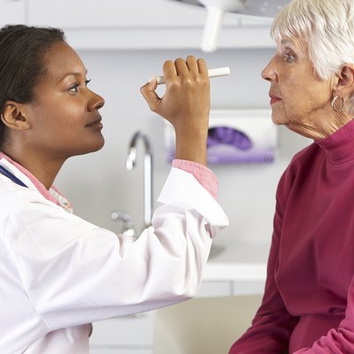Doctor Examining Senior Female Patient's Eyes