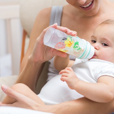 Mother feeding baby with milk bottle