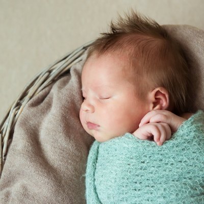 Newborn baby sleeps in a basket hairstyle Mohawk