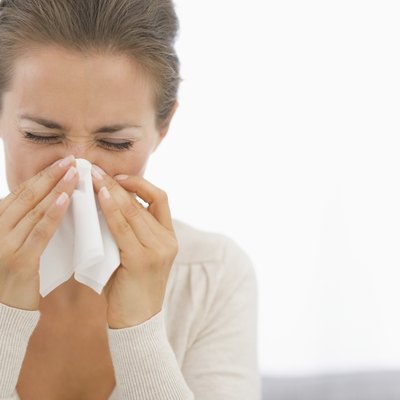 portrait of young woman blowing nose