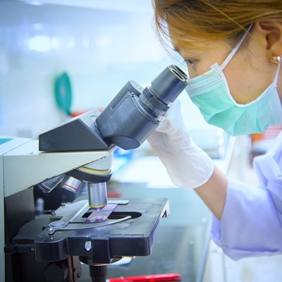 Scientist looking through a microscope in laboratory hospital