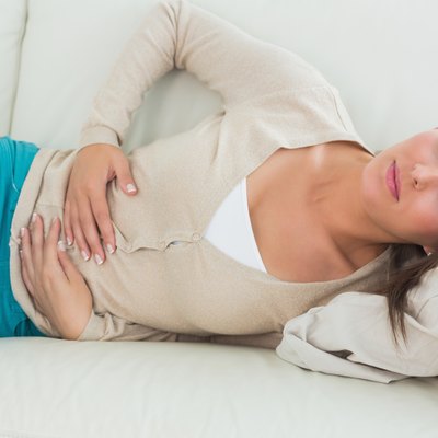 Woman lying on the sofa with upset stomach