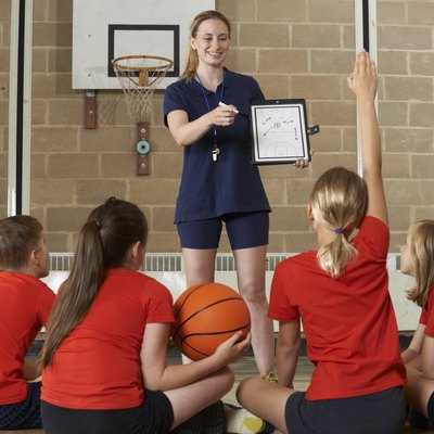 Coach Giving Team Talk To Elementary School Basketball Team