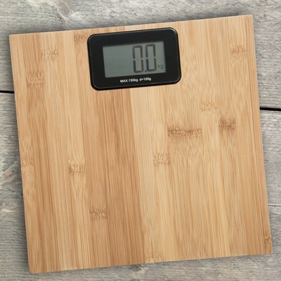 Electronic floor scale on a wooden background