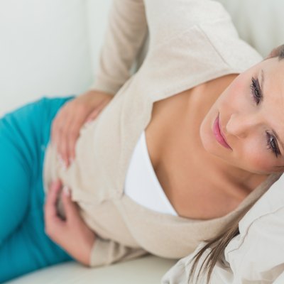 Woman lying on sofa looking sick