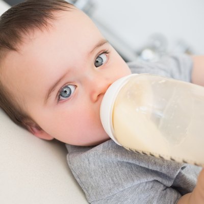 Baby drinking milk while lying on counter
