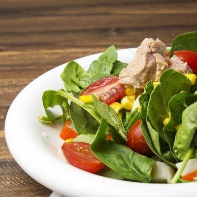 Fresh spinach salad with tuna and corn, cherry tomatoes