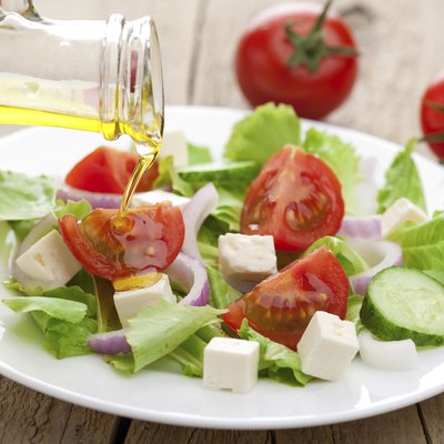 oil pouring over fresh salad