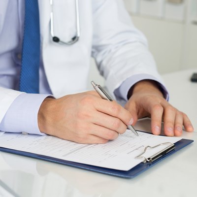 Close up of doctor's hands writing prescription