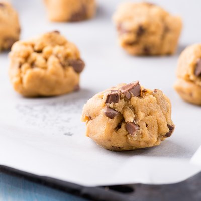 Raw cookie dough on a baking tray with parchment paper