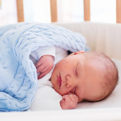 Newborn baby boy in hospital cot