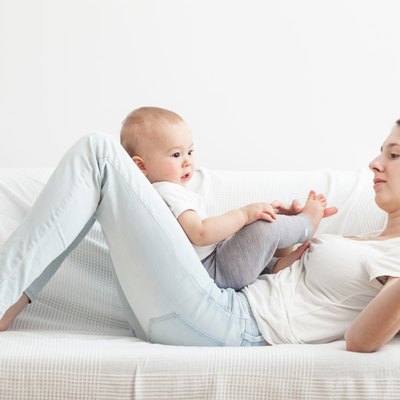 Mum playing with little child in the sofa