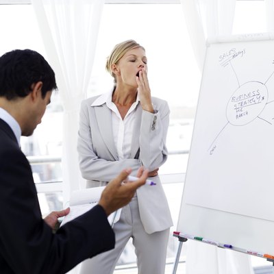 portrait of a young businesswoman yawning at a presentation