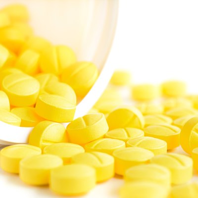 Small medicine tablets (or pills) spilling out from the bottle