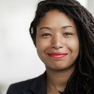 Portrait of smiling businesswoman with dreadlocks, head and shoulders