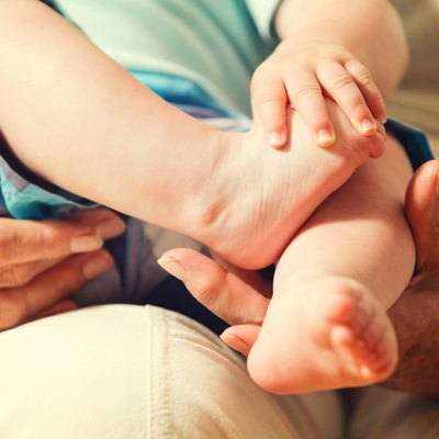 Grandmother's Hands Holding Newborn's Feet