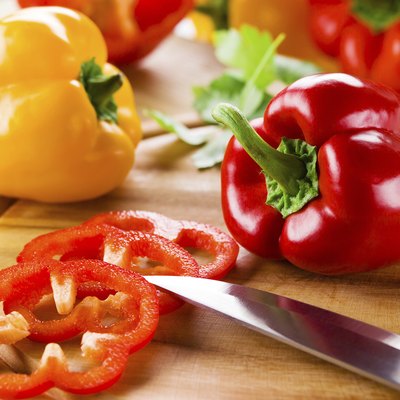 Organic paprika peppers with slice over wooden table