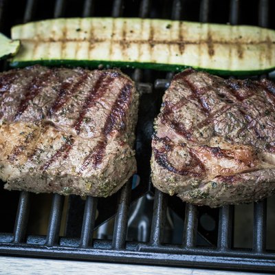 Two rib eye steak with zucchini on grill