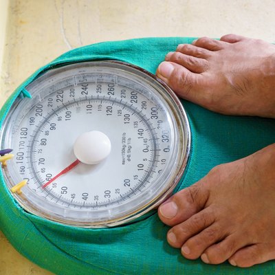 Man's feet standing on a weighing scale