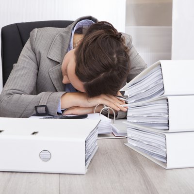 Exhausted Businesswoman Sleeping On Desk