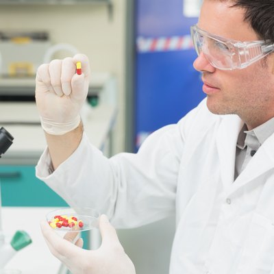 Male scientist analyzing pills in the laboratory