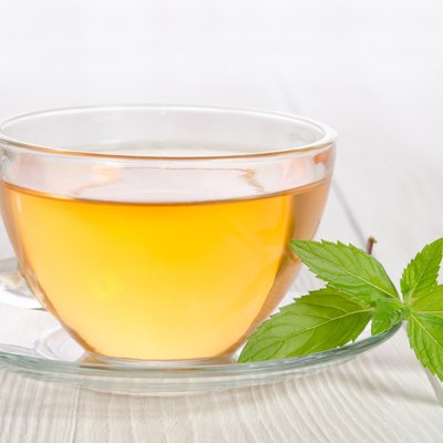 Glass cup of tea with mint on the wooden table