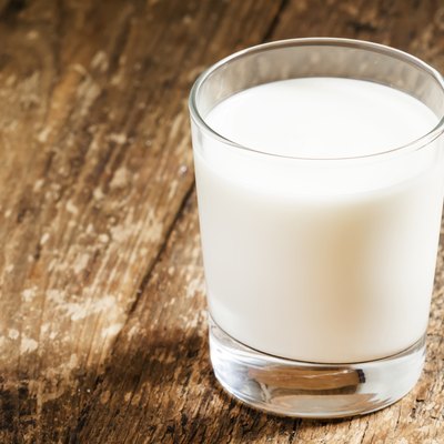 glass of fresh milk on old wooden table