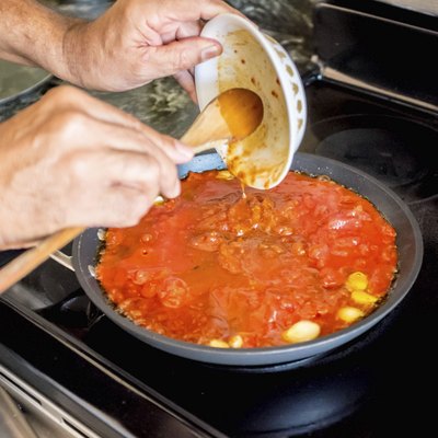 Emptying Ingredients into Frying Pan to make Italian Sauce