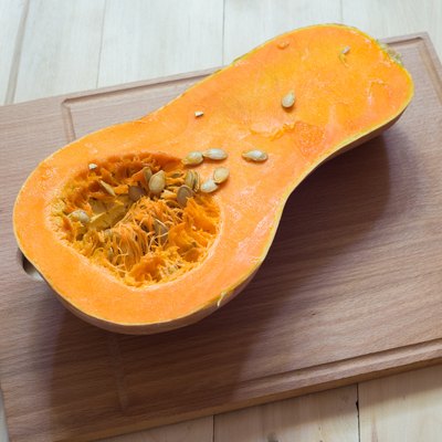 Butternut squash cut in half on a wooden surface
