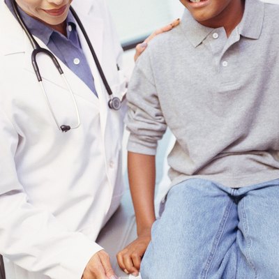 Female doctor testing boy's reflexes
