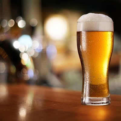 Glass of light beer on a bar counter