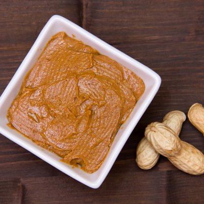 Bowl with peanut butter on wood from above