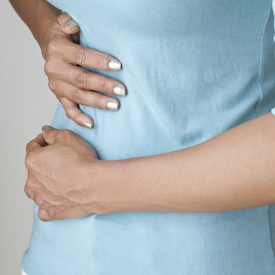 menstruation pain or stomach ache, hand holding belly closeup