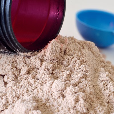 Black shaker in heap of chocolate protein powder
