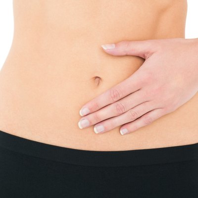 Close-up mid section of a fit woman with stomach pain